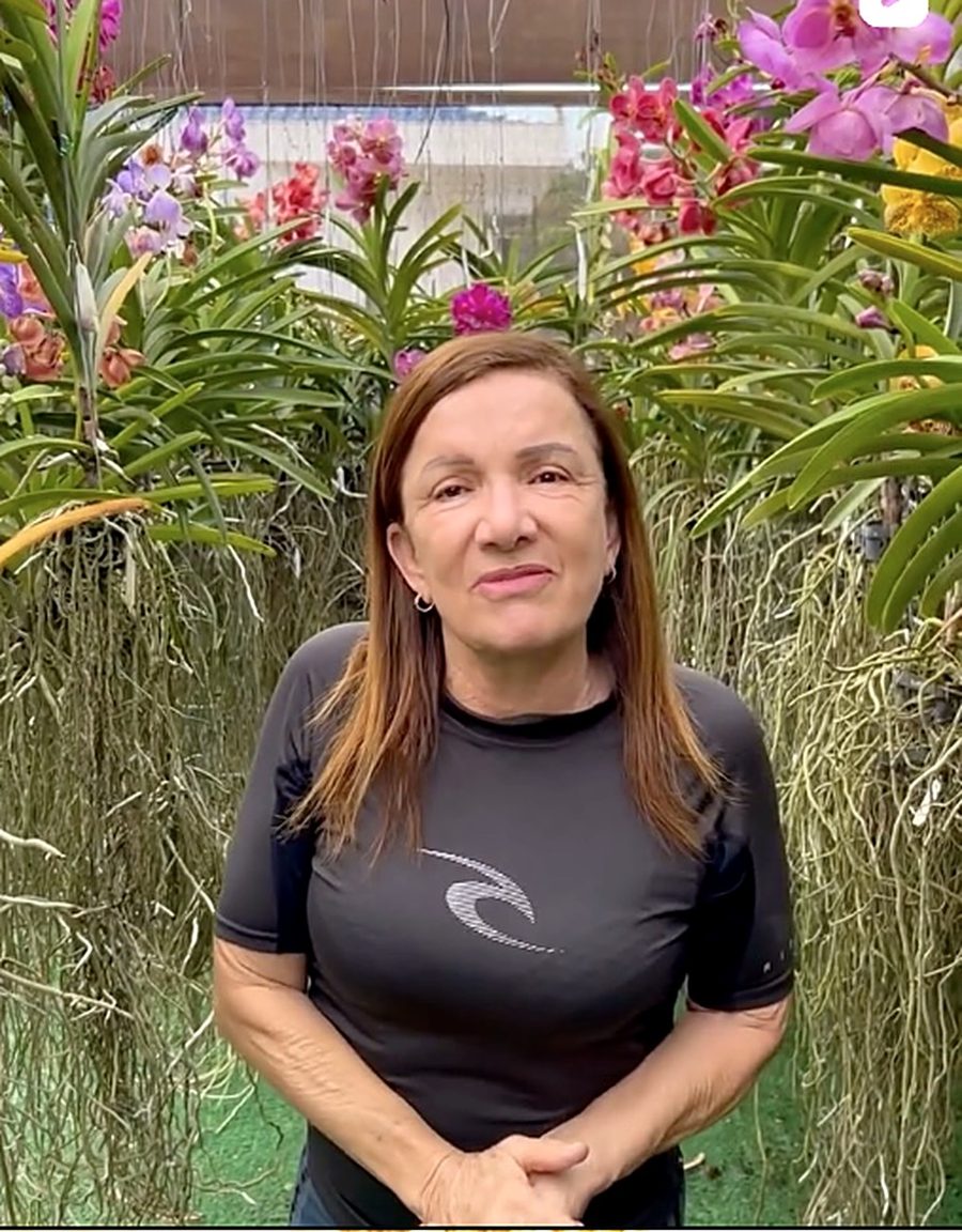 Rosângela Ávila no orquidário, entre Vandas floridas